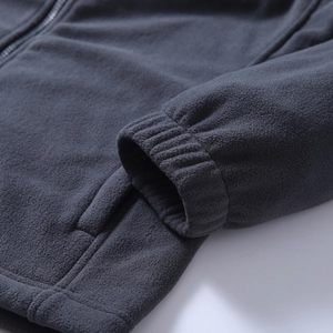 Detailed macro view of charcoal grey fleece jacket cuff with windproof elastic ribbing