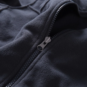Close-up of the smooth resin zipper and soft fleece texture on the dark grey jacket liner
