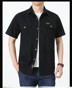 Close-up of black cotton utility shirt showing double breast pockets with buttoned flaps