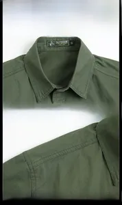 Detail view of olive green military shirt featuring classic collar and durable cotton fabric