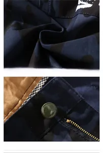 Detailed macro view of olive green button with Vogue lettering and metal zipper on cargo shorts