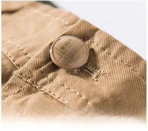 Close-up of durable khaki cargo shorts featuring a branded resin button and reinforced stitching
