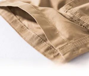 Detailed macro view of khaki cotton twill shorts hem featuring durable double-stitch seams