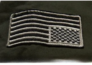 Macro shot of geometric embroidery patch on army green heavy cotton canvas jacket