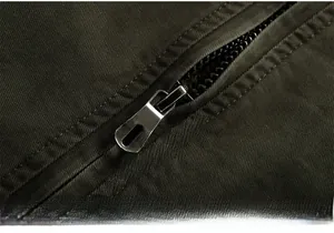 Detail of vintage metal zipper and olive green heavy duty fabric on men's winter jacket