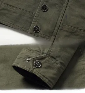 Detailed view of metal buttons on the placket and cuffs of a military canvas jacket