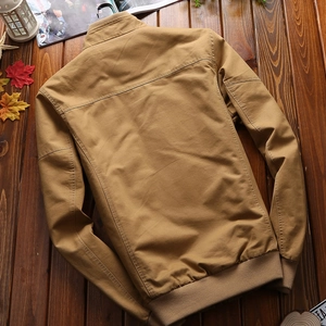Men's khaki stand collar flight jacket in cotton canvas laid on a rustic wooden background
