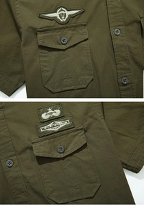 Detailed view of military patches and flap chest pockets on a green cotton cargo shirt