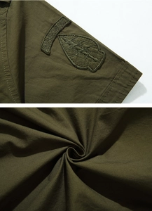 Detailed view of military-style army green shirt featuring airborne embroidered patch