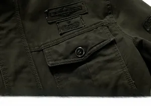 Detailed close-up of military olive green cotton jacket chest pocket with embroidery badges