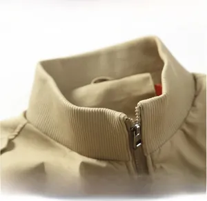 Detailed close-up of ribbed knit collar and metal zipper on khaki bomber flight jacket