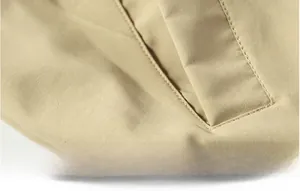 Detailed view of functional pocket with reinforced stitching on khaki flight jacket