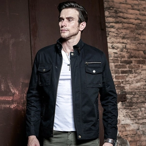 Veste de travail homme noire en toile avec poches multiples et col montant sur brique