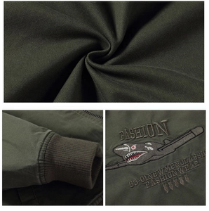 Close-up of olive green cotton canvas pilot jacket with shark embroidery and ribbed cuffs
