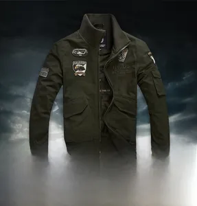Detail of military green bomber jacket featuring embroidered patches and canvas texture