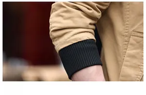 Close-up of khaki cotton jacket sleeve with elastic black ribbed windproof cuff detail