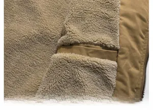 Close-up of MA1 flight jacket showing khaki cotton fabric and warm beige fleece lining