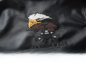Detailed embroidery featuring an eagle and helicopter on a black faux leather motorcycle jacket