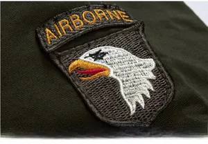Close-up of military eagle embroidery patch with airborne lettering on green jacket