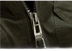 Detail view of military green cotton fabric with vintage alloy zipper and H.T.N engraving