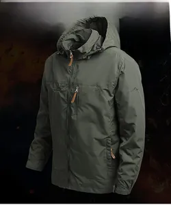 Détail d'une veste coupe-vent vert armée avec logo montagne brodé et poignets velcro