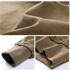 Détails d'une veste kaki montrant le tissu en sergé de coton et les poignets côtelés