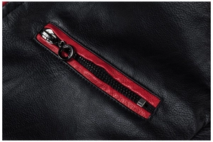 Detail einer schwarzen Lederjacke mit roter Kontrasttasche und strukturierter Oberfläche
