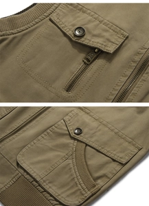 Detailed macro view of multi-pocket canvas vest showing stitching and metal hardware quality