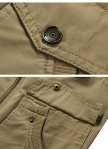 Detail view of khaki cotton twill tactical vest with metal snap buttons and heavy zippers