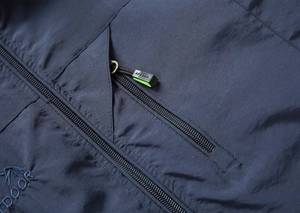 Dettaglio del gilet outdoor blu scuro con cerniere funzionali e logo ricamato