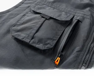 Detail of waterproof nylon fabric and functional utility pocket with orange zipper puller
