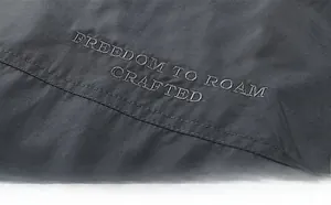 Detail of dark gray outdoor vest featuring Freedom to Roam crafted embroidery logo