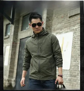 Detailed view of army green outdoor tactical jacket with hooded design and arm badge