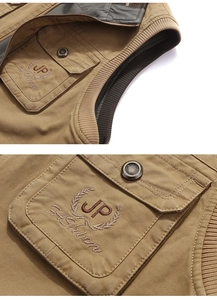 Dettaglio del gilet multitasche kaki con ricamo vintage e bottoni in metallo bronzato