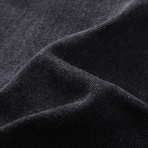 Close-up of premium black denim fabric showing high-density twill weave and texture