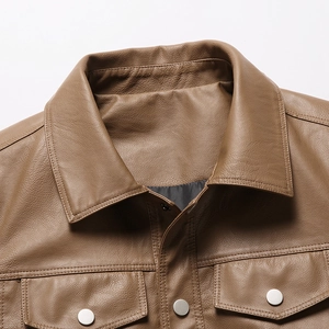 Detailed close-up of brown leather jacket lapel featuring metallic snaps and grain texture