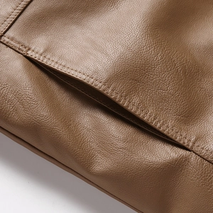 Detailed close-up of brown faux leather texture with neat stitching on a biker jacket