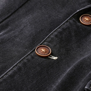 Detail of dark denim fabric with classic brown buttons and neat contrast stitching