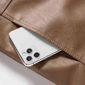 Macro shot of the exterior pocket on a brown leather jacket showing fine stitching and texture