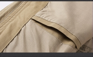 Détail du gilet en coton kaki avec fermeture éclair en métal et texture en tissu sergé