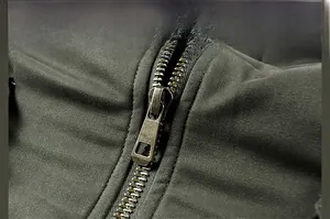 Close-up of durable bronze-colored metal zipper on dark green workwear jacket