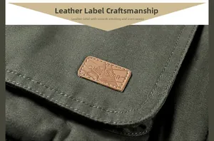 Detail of outdoor jacket showing canvas fabric with brown leather patch and clean stitching