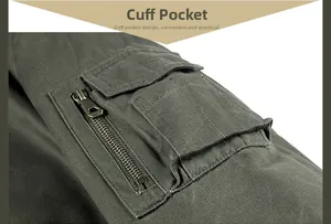 Detail of army green work jacket sleeve featuring a utility zipper pocket and cotton fabric