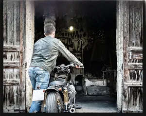 Detail of men's fleece-lined work jacket with a vintage motorcycle in the background