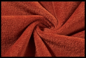 Macro detail of soft thick coral fleece fabric in deep orange for men's winter hoodies