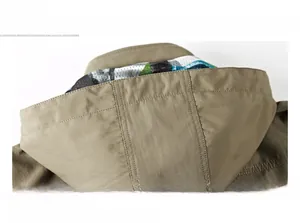 Detail of khaki hooded outdoor jacket showing reinforced seams and breathable mesh lining