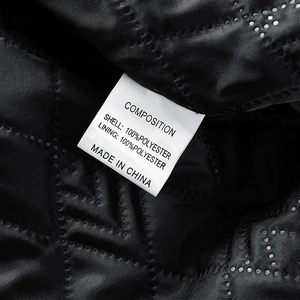 Black quilted inner lining of men's jacket with fabric composition care label
