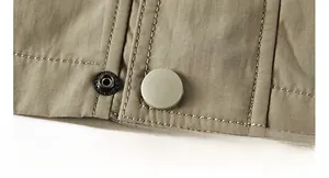 Detailed close-up of heavy-duty metal press studs and reinforced stitching on jacket