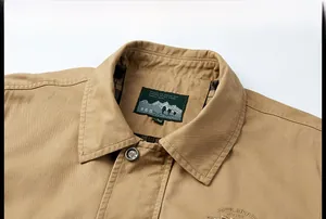 Détail du col d'une veste décontractée kaki pour homme avec étiquette brodée et bouton métallique