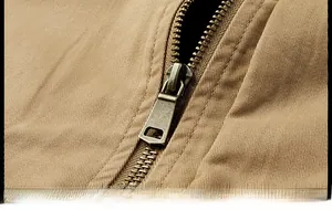 Détail de la fermeture éclair en bronze et du tissu en sergé kaki de la veste homme